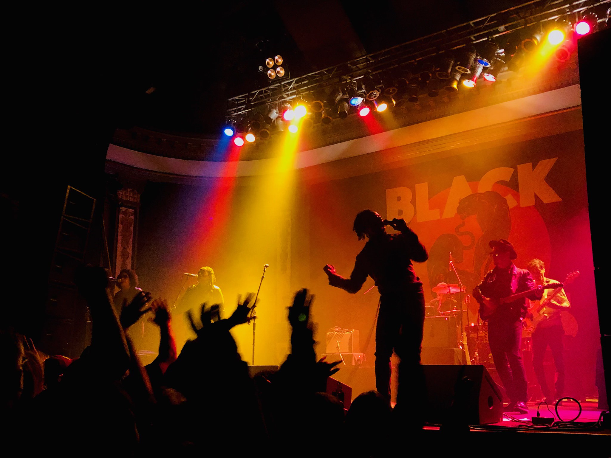 Live music performance with dramatic stage lighting and engaged audience